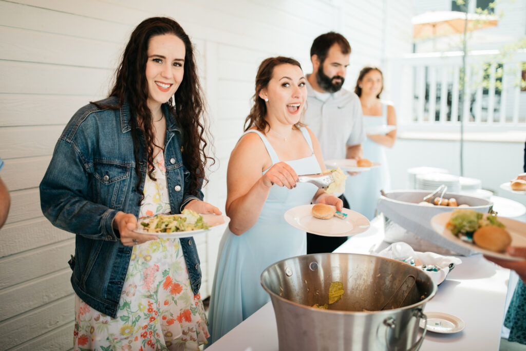 image shows wedding guests in a buffet line for meal time