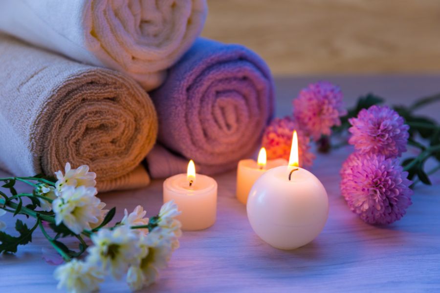 image shows candles and rolled towels in a relaxing environment