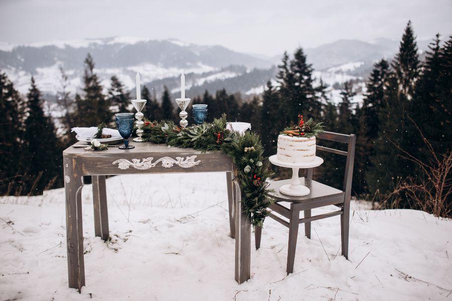 image shows a table and cake set up with a mountain view in winter