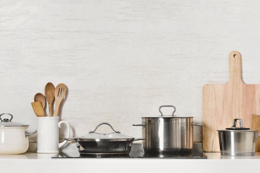 image shows pots and pans and kitchen accessories on a stovetop