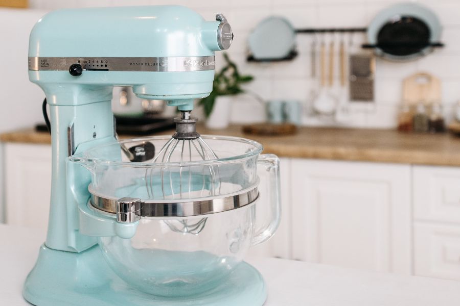 image shows a blue stand mixer on a counter in a kitchen