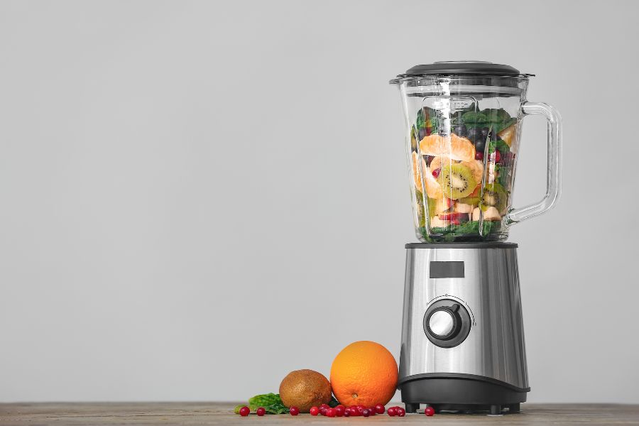 image shows a blender filled with fruits