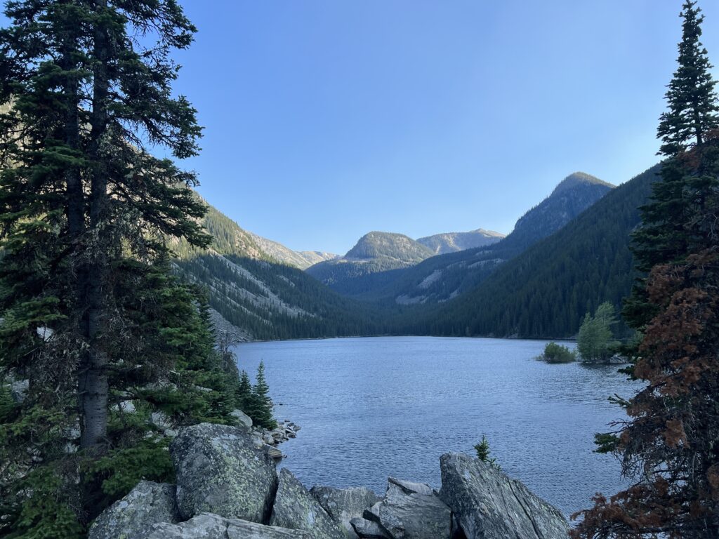 image shows a lake surrounded by mountains and trees