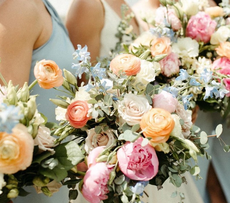 image shows bridesmaids holding large floral boquets