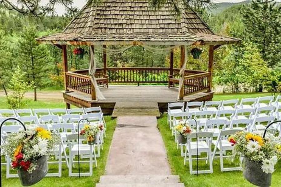 image shows an outdoor wedding ceremony location with seating and a gazebo