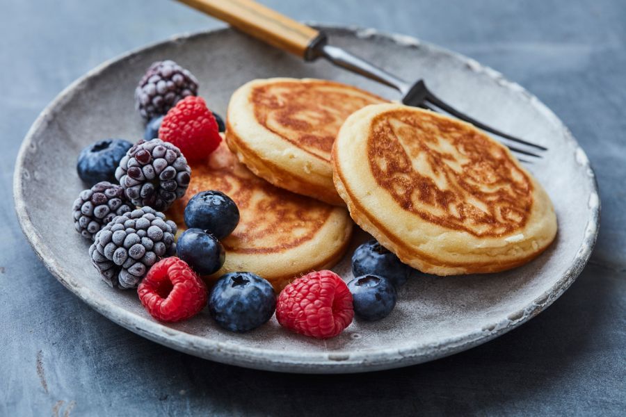 image shows pancakes and berries on a plate