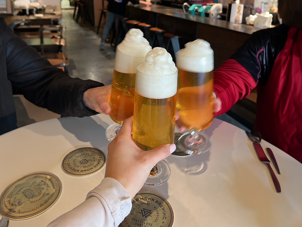 image shows 3 people toasting their beers