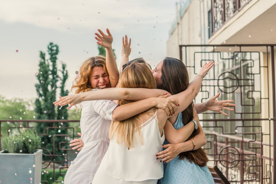 image shows 3 women hugging