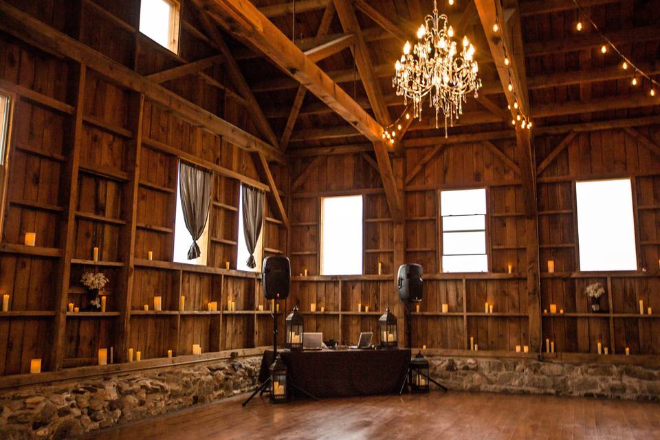 image shows the interior of a rustic wedding venue with dramatic lighting