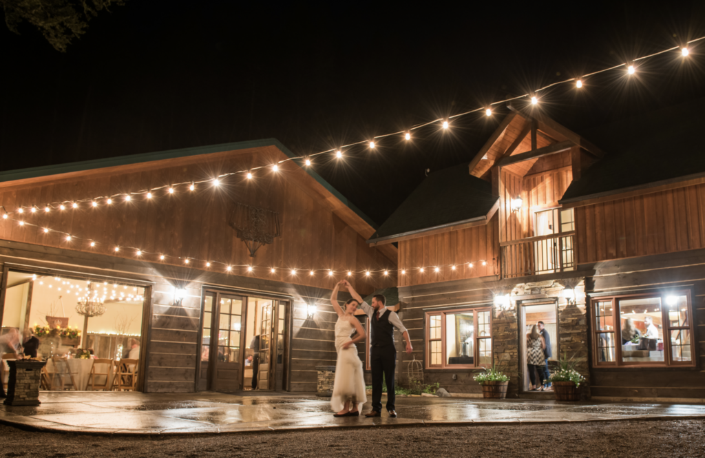 image shows a groom dancing and twirling his bride outside at a bozeman wedding venue