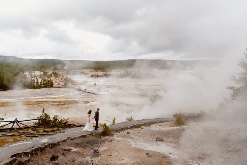 image shows a bride and groom walking through a steamy thermal area