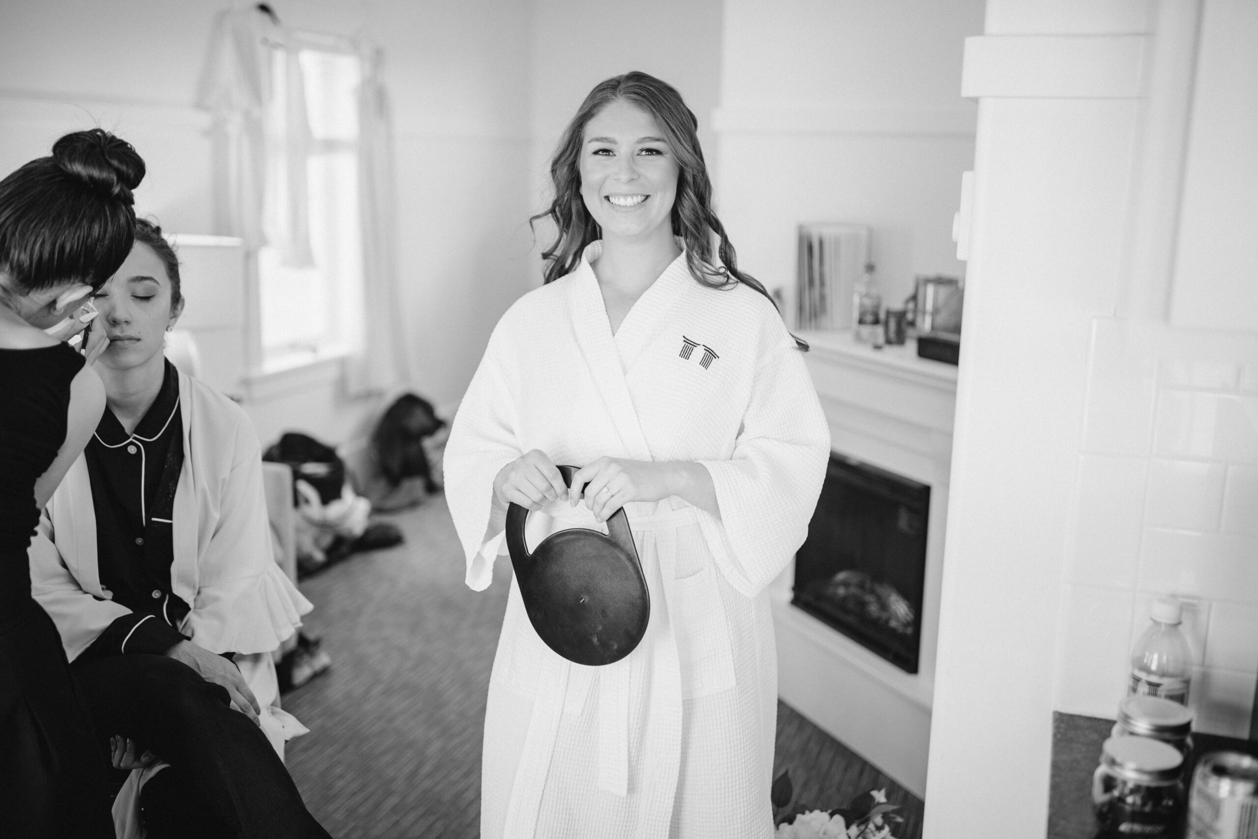 image shows a smiling woman in a robe appearing to get ready for something