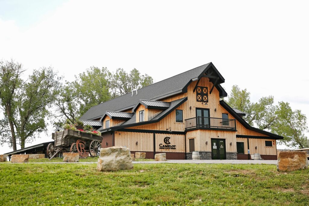 image shows a beautiful big barn with a lush grass foreground