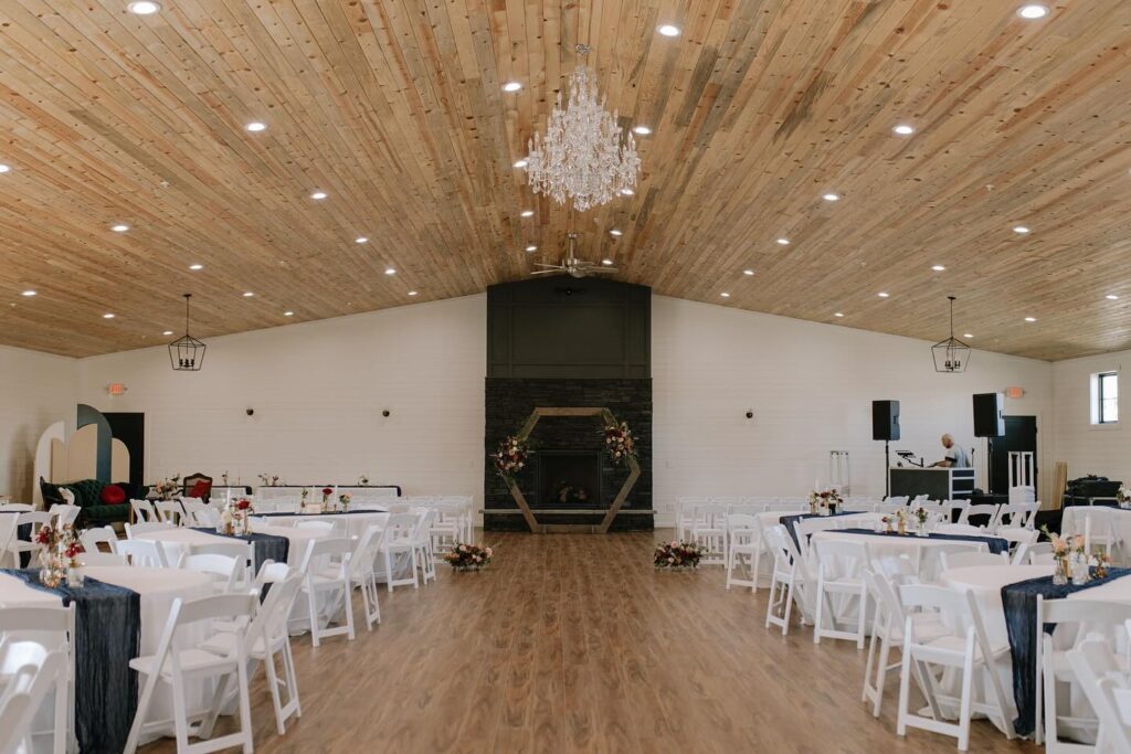 image shows a modern wedding barn with reception tables set up